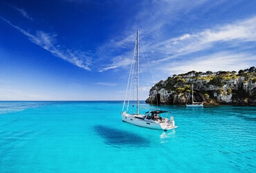 Ein Segelboot liegt im klaren blauen Wasser vor Anker.